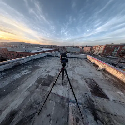 Tripod and camera on a rooftop for telecommunications survey